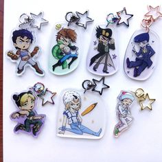 six keychains with cartoon characters on them sitting on top of a piece of paper