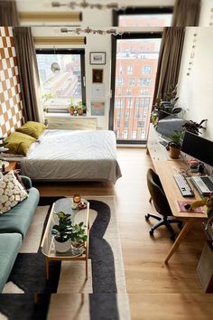 a room with a bed, couch and desk in it's own home apartment