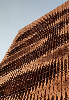 the side of a building that is made out of bricks and has many holes in it