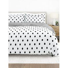 black and white polka dot bedding in a bedroom with wood flooring on the side