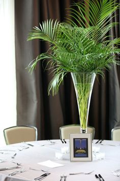 there is a plant in a vase on top of a table with silverware and napkins