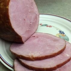 slices of ham on a plate next to a loaf of bread