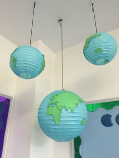 three paper globes hanging from the ceiling