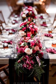 the long table is set with pink and white flowers