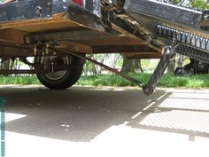 the back end of a vehicle with metal parts on it's sides and wheels