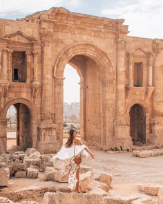 a woman standing in front of an ancient building