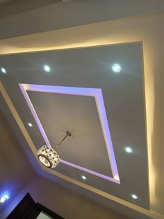 a ceiling with lights and a key hanging from it's center beam in a room