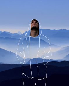 a man standing on top of a mountain with mountains in the background