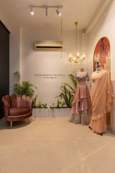 mannequins are displayed in front of a wall with paintings and chandeliers