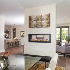 a living room filled with furniture and a fire place next to a dining room table