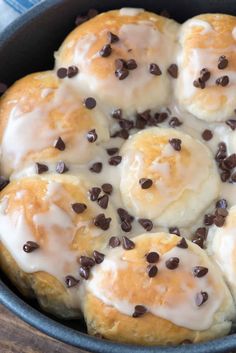 chocolate chip donuts with icing and chocolate chips in a cast iron skillet