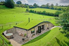 an aerial view of a house with a grass roof and hot tub in the yard