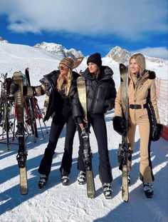 three women are standing in the snow with their skis and poles attached to them