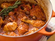 a red pot filled with meat and vegetables