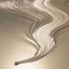 a black and white photo of water ripples in the sand with a star on top