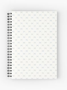 a spiral notebook with white and blue bows on the front, lined in two rows