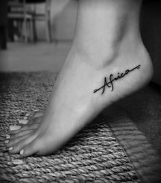 a woman's foot with the word affirm on it and an arrow tattoo