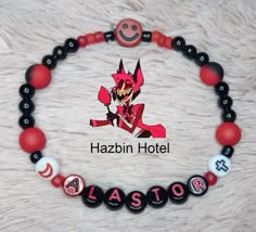 a red and black beaded bracelet with an evil demon