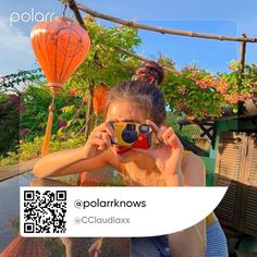 a woman taking a photo with her cell phone in front of some hot air balloons