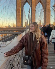 a woman standing on the side of a bridge