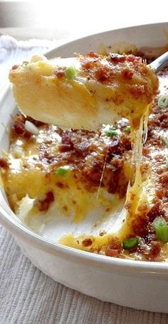 a white bowl filled with lasagna casserole covered in cheese