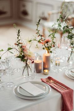 the table is set with flowers and candles