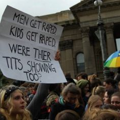 a group of people holding up signs in front of a building