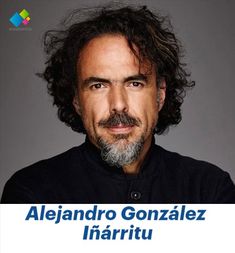 a man with long curly hair and a beard wearing a black shirt is looking at the camera