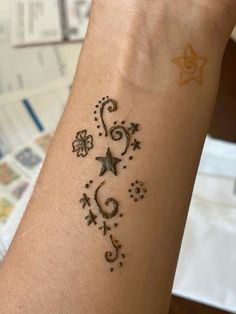 a woman's arm with a tattoo on it and stars in the middle of her arm