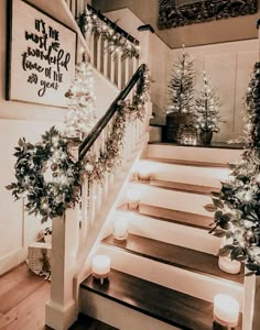 stairs decorated with christmas lights and greenery for the holiday season, lit by candles