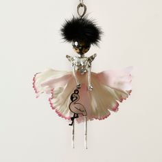 a key chain with a doll hanging from it's side and a bird on top