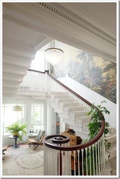 a staircase leading up to a living room with a painting on the wall behind it