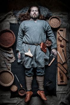 a man with long hair standing in front of various items