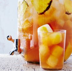 a mason jar filled with water and lemon slices next to a glass of iced tea