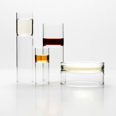 three glasses with different liquids in them sitting next to each other on a white surface