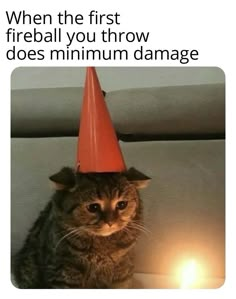 a cat with a red hat on top of it's head sitting next to a lit candle