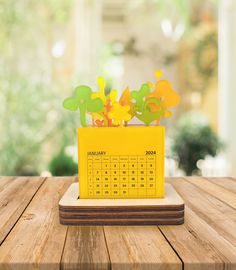 a wooden table topped with a yellow calendar