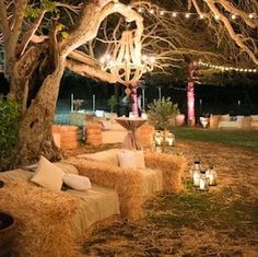 an outdoor seating area with hay bales and candles