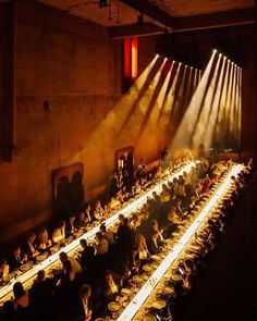 an overhead view of a long table with many people sitting at it in the dark