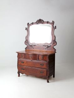 an old dresser with a mirror on the top and drawers below, against a white background