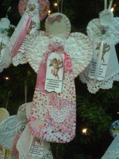 an angel ornament hanging from a christmas tree with tags attached to it's sides