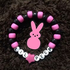 a pink and black beaded bracelet with a bunny on it