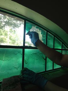 a person with gloves on is cleaning a window