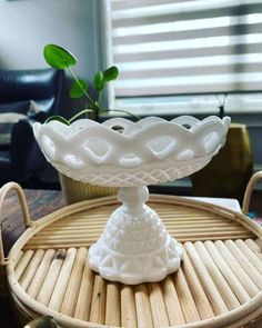 a white vase sitting on top of a bamboo tray