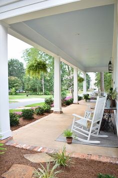 a white rocking chair sitting on top of a porch