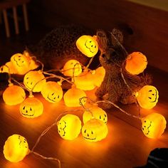 some pumpkins that have been placed on the floor with lights around them and faces drawn on them