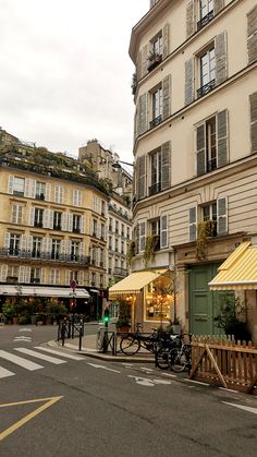 an empty street with tables and chairs in front of buildings