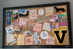 a cork board covered in magnets and post - it notes with the letter v