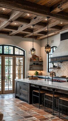 a large kitchen with an island and two hanging lights