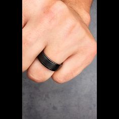 a man's hand with a black ring on it